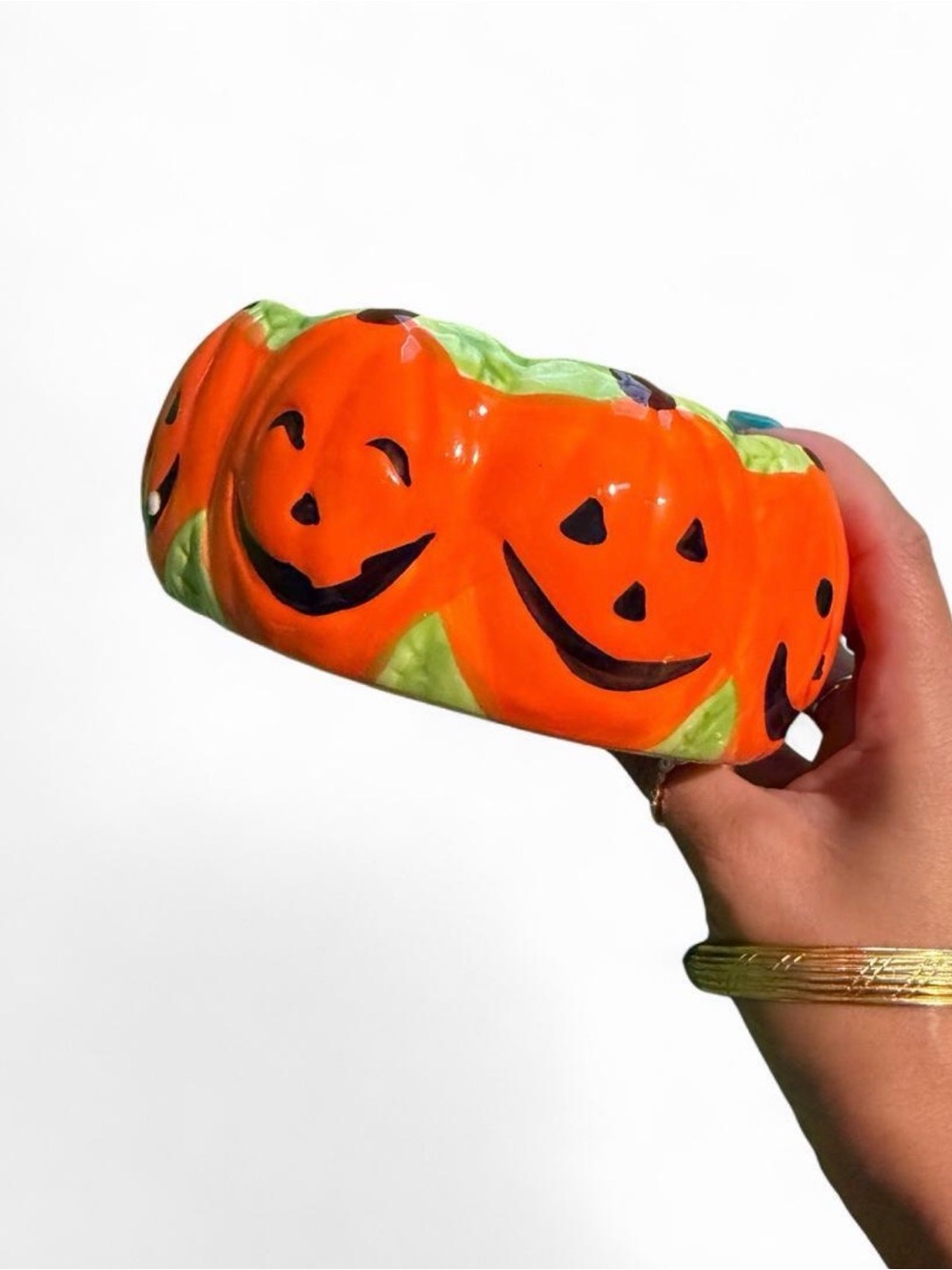 Orange pumpkin bowl with green stems and jack-o'-lantern faces